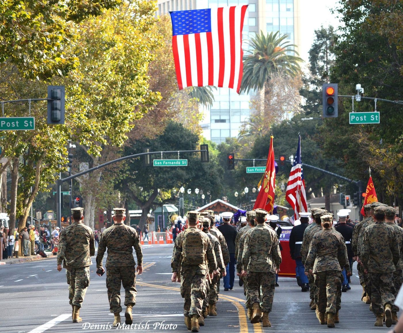Marines marching under a giant American flag